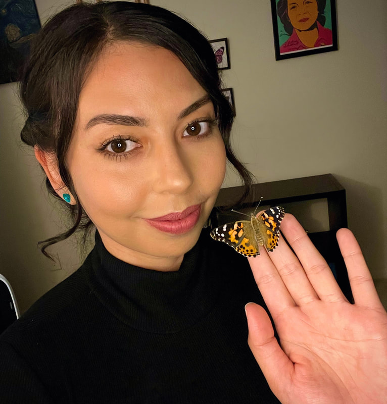 Woman holding butterfly on fingertip.